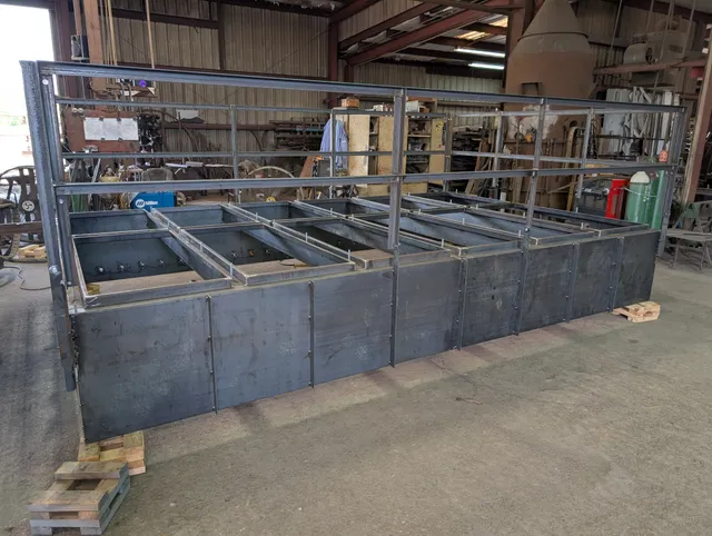 Long multi-bay welded steel trough frame assembly on the shop floor