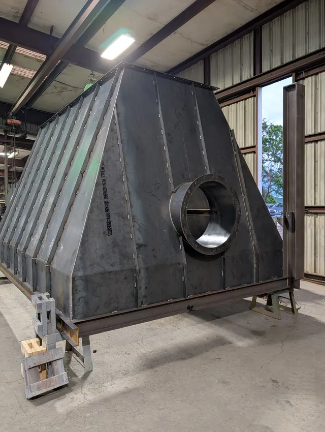 Large pyramidal steel hopper with round discharge port being fabricated in the shop